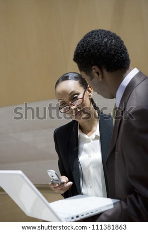 African American business people talking while using laptop