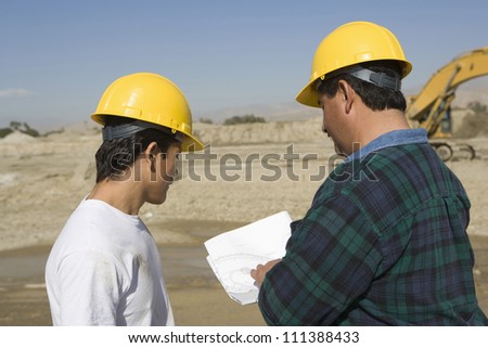 Male architects wearing hard hat at construction site