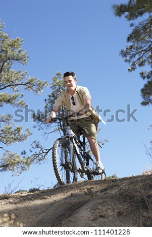 Caucasian male riding cycle on dirt road