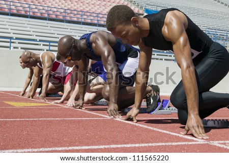 Male athletes at starting line in track race
