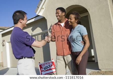 Asian real estate agent with couple buying new house