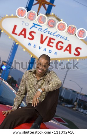 African American young man in front of a \'Welcome to Las Vegas\' sign
