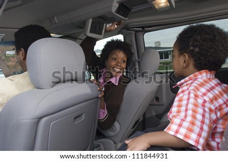 Portrait of an African American woman sitting in car with small boy in foreground