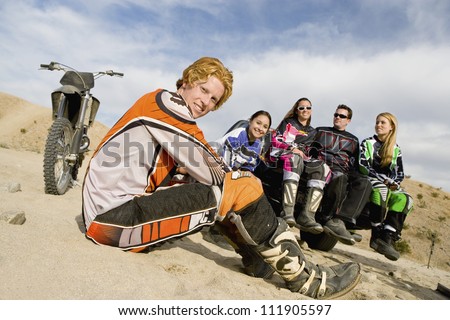 Group Of Motocross Racers sitting in the sand