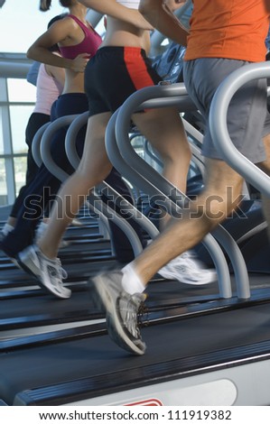 Low section of people exercising on treadmill