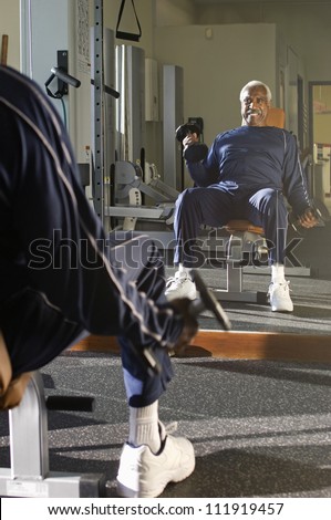 Senior man lifting weights at a gym