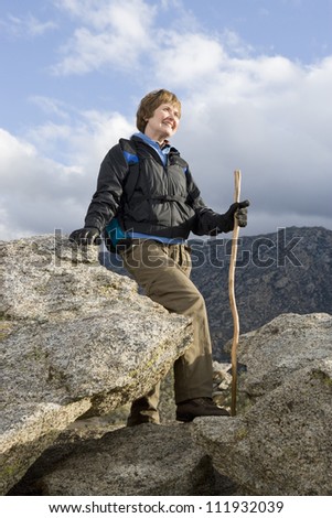 Happy senior female hiker with hiking stick