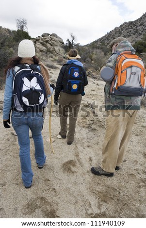 Senior couple and daughter with sticks hiking