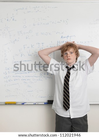 Portrait of a young male student standing in front of the white board