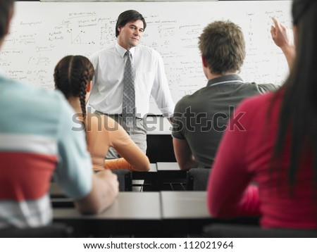 Students studying with professor in classroom