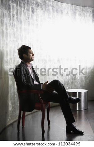 Full length of man in suit sitting