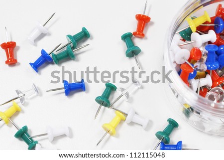 Close-up of colorful push pins over white background