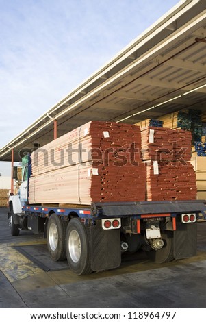Truck loaded with wood outside warehouse