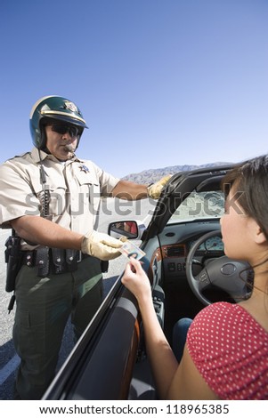 Police officer checking driver\'s ID