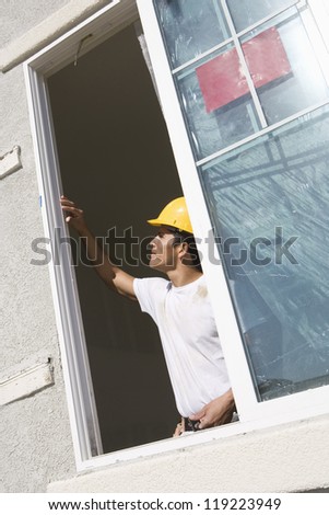 Construction Worker examining window frame