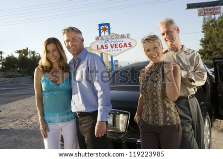 Two couples posing in front of Welcome to Las Vegas sign, group portrait