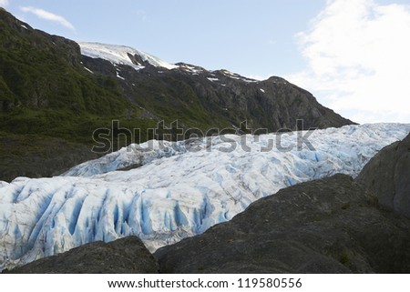 Landscape of snow covered land with glaciers between rock cliffs
