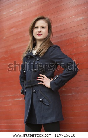 Beautiful young business woman standing with hands on hips looking away