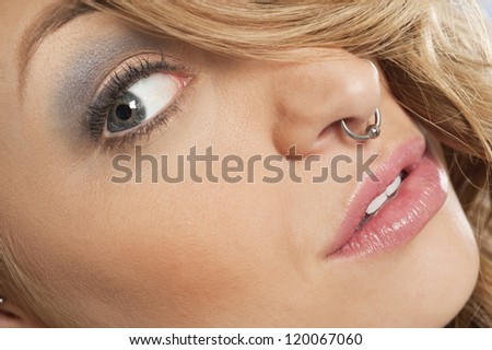 Cropped image of beautiful young woman with nose ring looking sideways