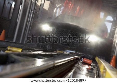 Motion blur shot of a front view of car passing through car wash process
