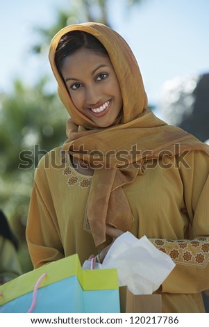 Portrait of a happy Indian woman holding shopping bags