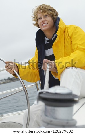 Happy young Caucasian man holding rope of the winch