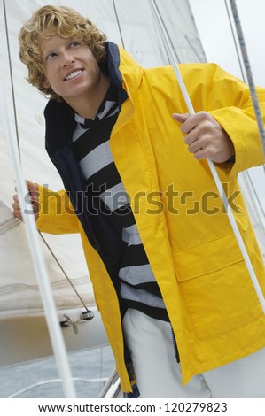 Young Caucasian man looking away on sail boat