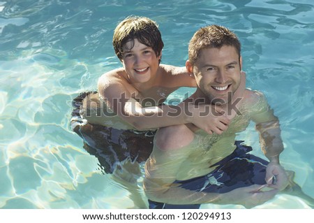 High angle view of happy father and son enjoying in swimming pool