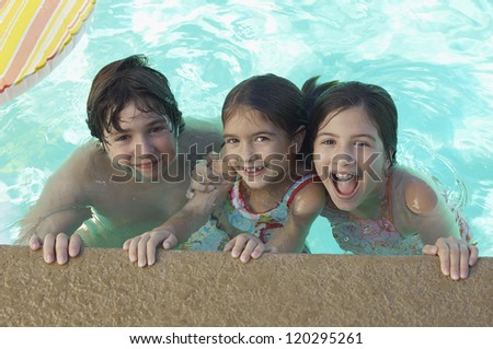 High angle view of brother and sisters together at edge of swimming pool