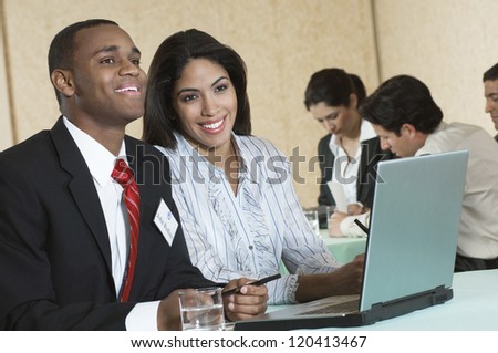 An African American business people smiling with colleagues in the background