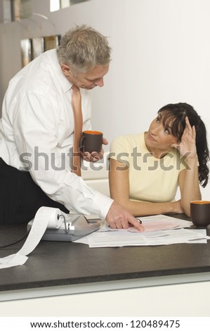 Senior financial adviser explaining document to woman in office