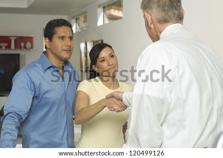Happy couple seal a deal with their personal financial adviser at home