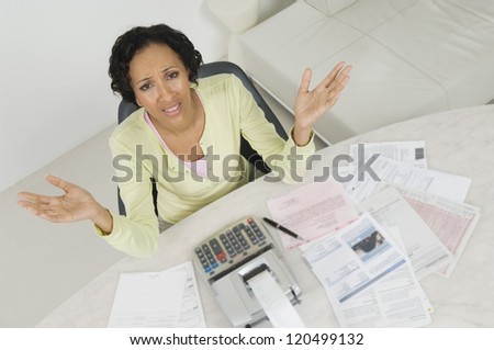 High angle view of a frustrated African American woman with documents and receipt expense at home