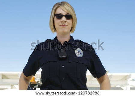 A female police officer standing smiling outdoors