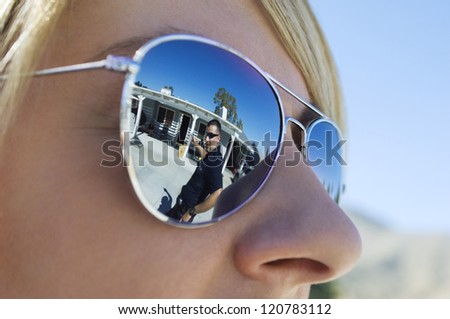 Police officer reflecting in sunglasses of coworker
