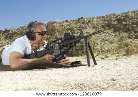 Side view of a man in shooting position on shooting range