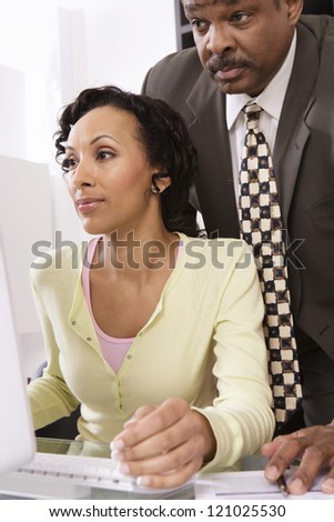 Two colleagues watching computer screen at office