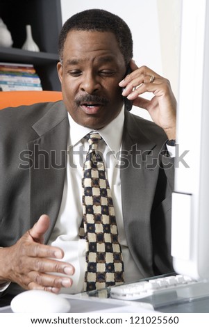 African American businessman using cell phone at office