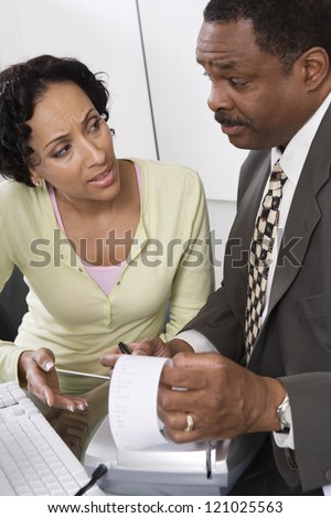 Male accountant with female client discussing at office