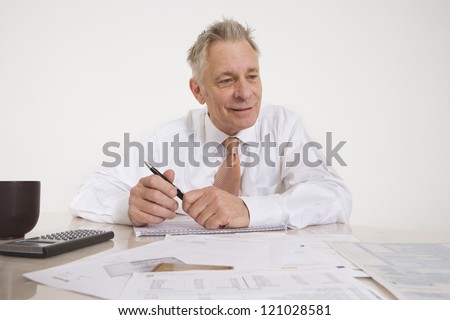 Senior businessman sitting with documents at office