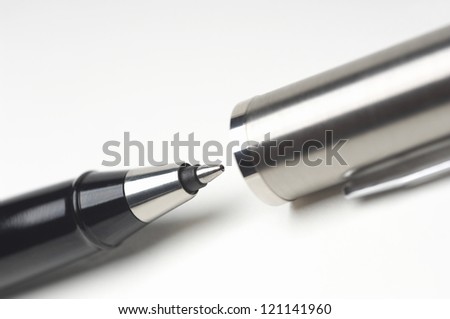 Cropped image of ballpoint pen isolated with cap over white background