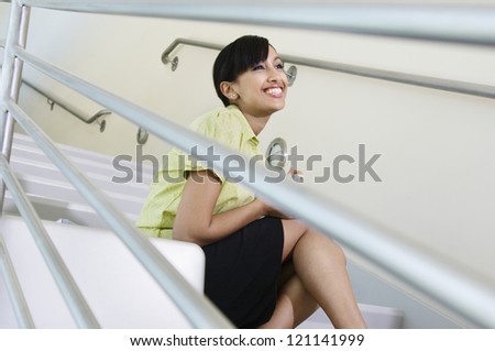 Low angle view of a young business woman smiling on stairs