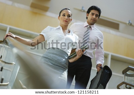 Low angle view of  business people walking down stairs in the office