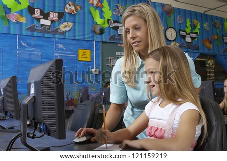 Teacher and student using computer in lab
