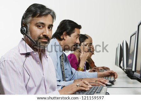 Portrait of a male customer service operator with colleagues in the office