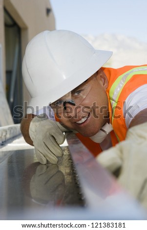 A happy male industrial worker with measuring instrument