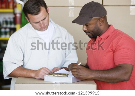 An African American male mechanic preparing bill for his customer