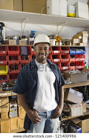 Portrait of a happy industrial worker wearing hardhat at workplace