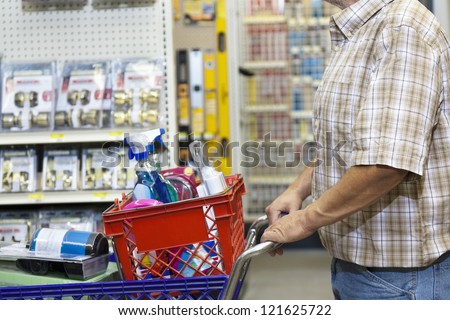 Midsection of man with shopping cart in hardware store