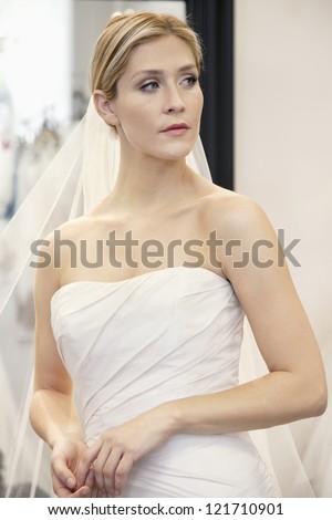 Beautiful young woman dressed up in wedding gown looking away